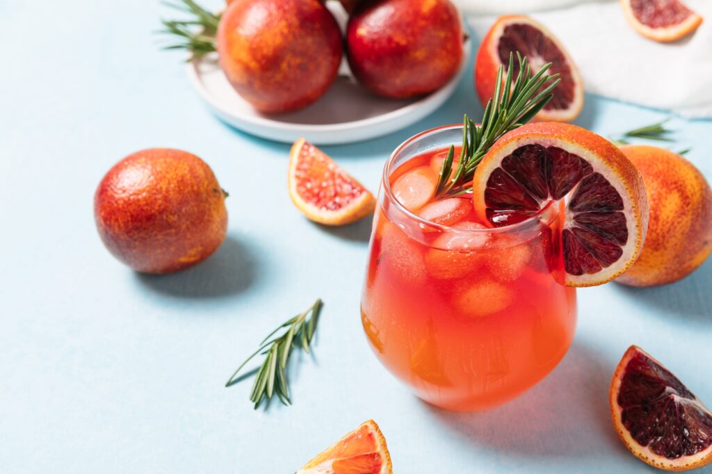 Delicious Blood Orange Cocktail on light blue background.